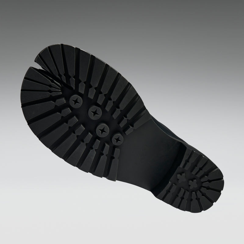 Black rubber sole of a boot on a gray background