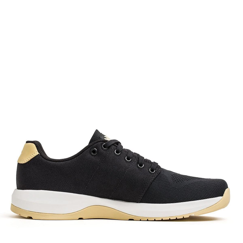GORUCK Ballistic Trainer black sneaker with gold heel and white sole on white background