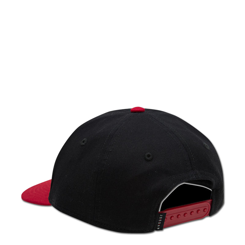 Black youth snapback cap with red underbrim and side eyelets