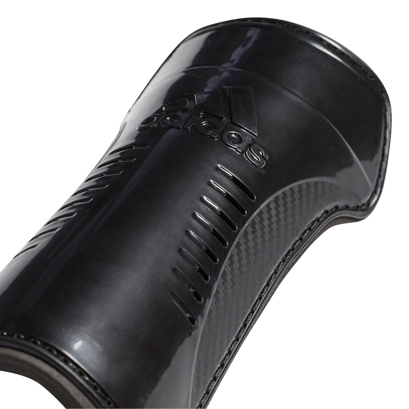 Black molded sock guard shell with vented slits and fastening buckle detail